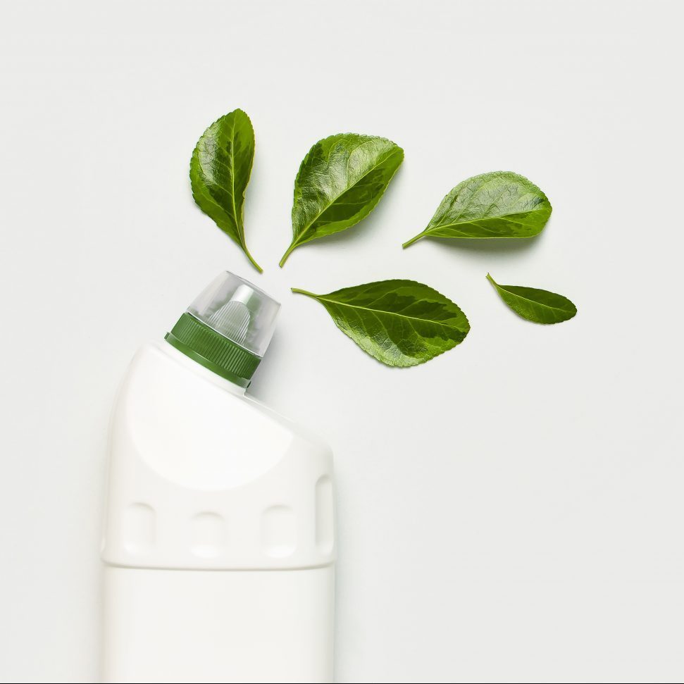 Weiße Reinigerflasche mit grünen Blättern